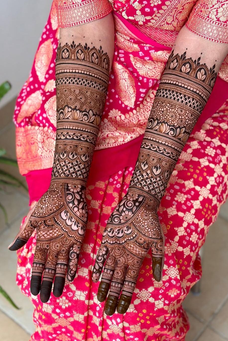 Full hand design with symmetrical floral vines and grid-style filler.